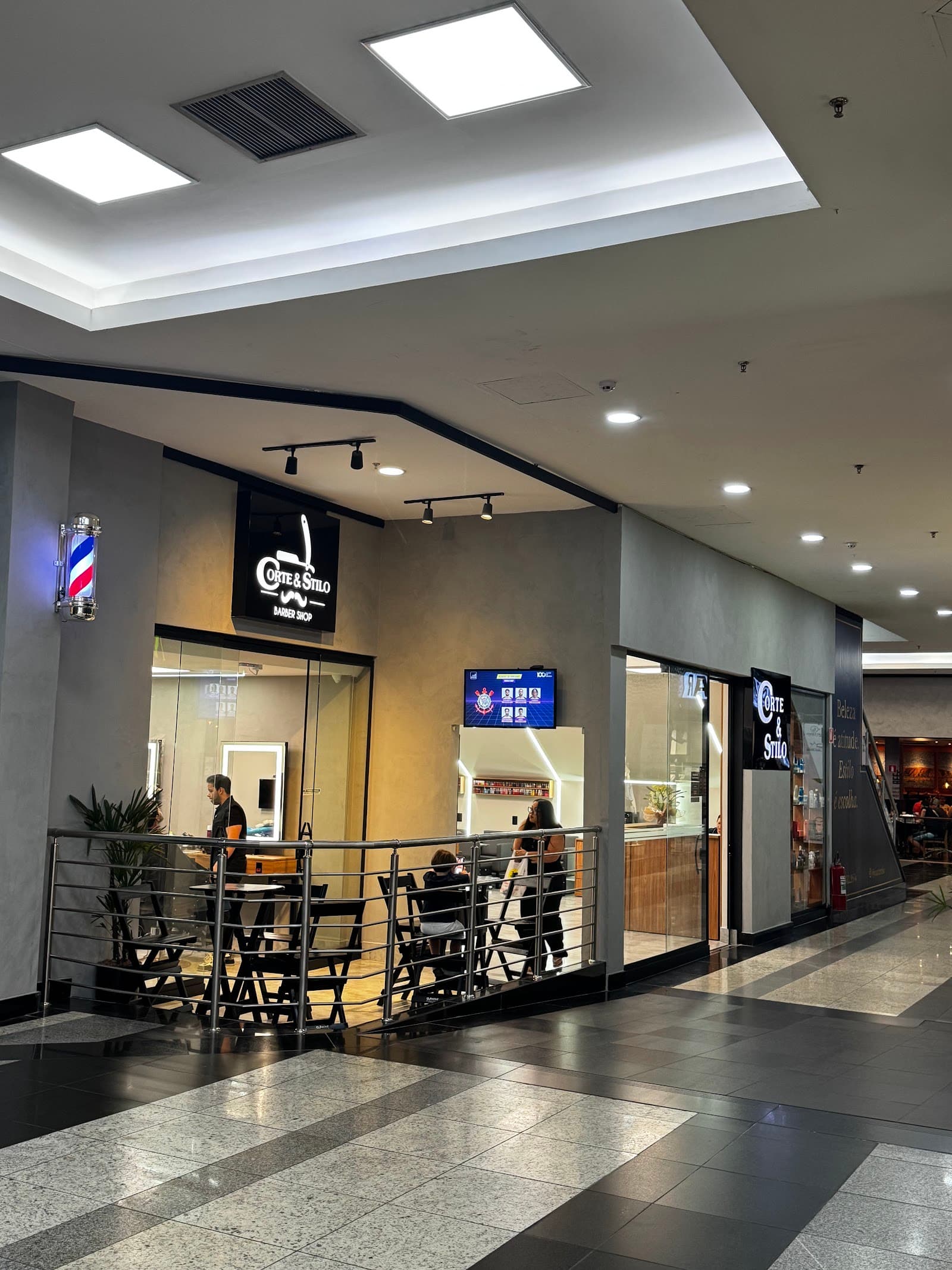 Fachada da Corte & Stilo no corredor do Pátio Limeira Shopping, com o letreiro, o poste de barbearia e as vitrines
